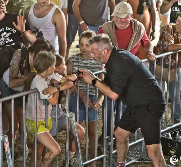 De zanger zingt samen met kinderen aan de nadarafsluiting