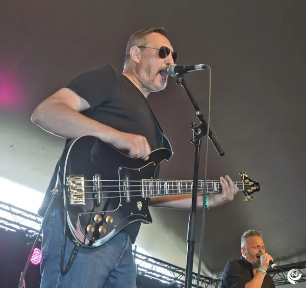 Bassist met zonnebril zingt mee